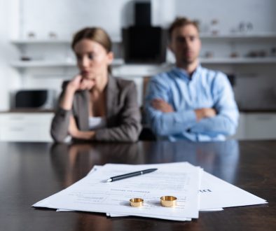selective focus of couple sitting at table with divorce documents